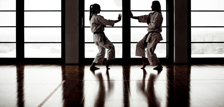 Karate practitioners in white gi performing a precise kick with focused expression Karate practitioners in white gi performing a precise kick with focused expression