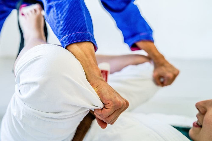 BJJ practitioners in gi training ground techniques with focus on submissions BJJ practitioners in gi training ground techniques with focus on submissions