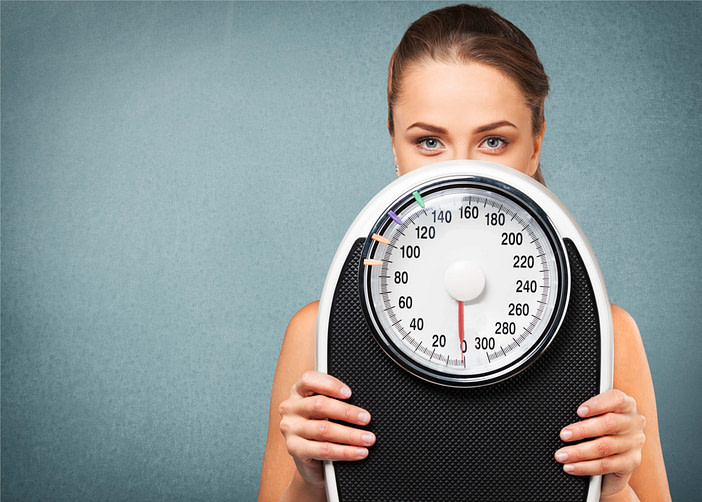 Woman Holding Scale Woman Holding Scale | Fighting Arts Health Lab