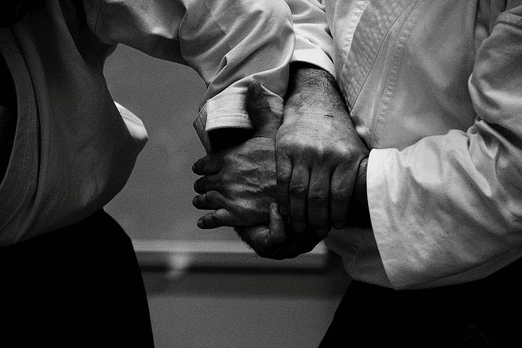 Two aikidokas engaged in hand lock Two aikidokas engaged in hand lock | Fighting Arts Health Lab
