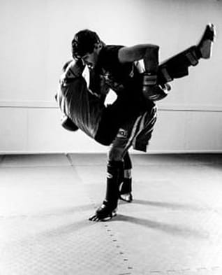 Savate Sam In Action Savate coach Sam Byford-Winter catching a kick and lifting a training partner