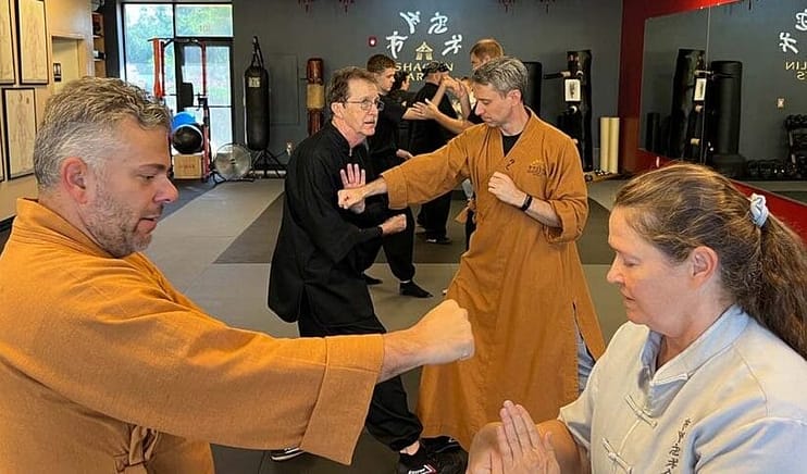 Adults drilling self-defense applications in pairs at a Tai Chi and kung fu school Adults drilling self-defense applications in pairs at a Tai Chi and kung fu school