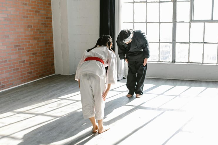 Karate instructor and young student bowing to each other in the dojo