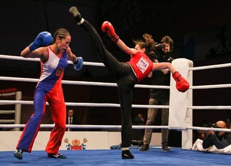 Savate Olympic Level Competition Two women in a savate bout, one landing a high kick to the head in the ring