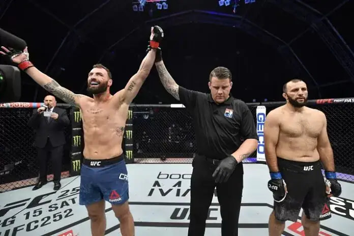 Professional MMA fighter in octagon with hands raised after victory, showing the culmination of years of training and discipline Professional MMA fighter in octagon with hands raised after victory, showing the culmination of years of training and discipline