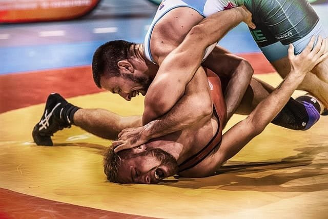 Wrestler demonstrating takedown control technique - ancient combat system for physical dominance and positional control Wrestler demonstrating takedown control technique - ancient combat system for physical dominance and positional control