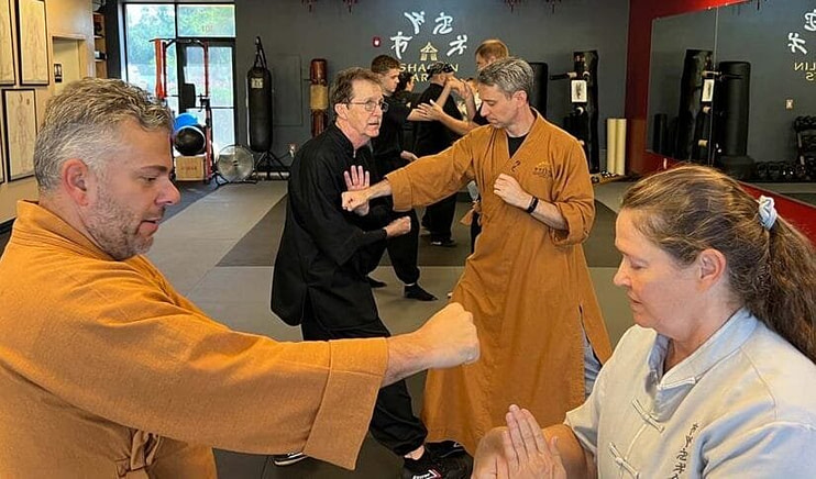 Mature martial arts instructor demonstrating effective self-defense technique to dispel myths about gentle martial arts effectiveness Mature martial arts instructor demonstrating effective self-defense technique to dispel myths about gentle martial arts effectiveness